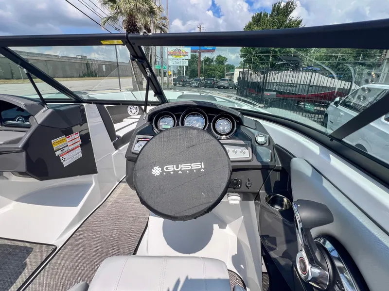 Slide: The Image of 2024 Monterey 218 SS boat dashboard with Gussi Italia steering wheel, modern controls, and gauges. - 11