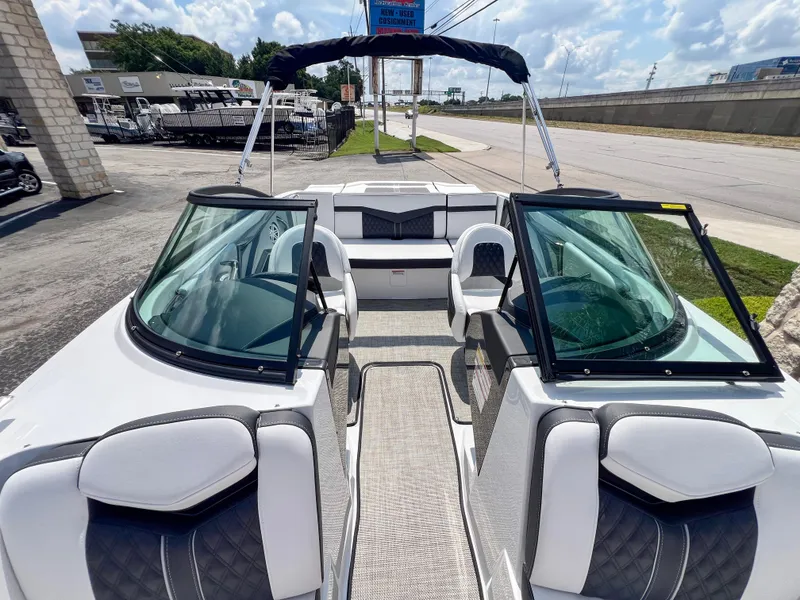 Slide: The Image of 2024 Monterey 218 SS boat interior with seating and windshield, parked outdoors. - 17