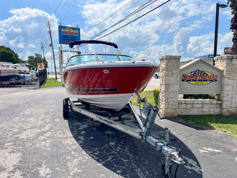 Slide: The Image of 2024 Monterey 218 SS boat on trailer, parked outdoors under a sunny sky. - 4