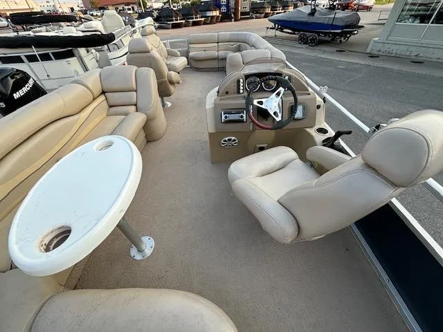 Slide: The Image of 2009 Bennington 2575RLi pontoon boat interior with beige seating and steering console. - 10