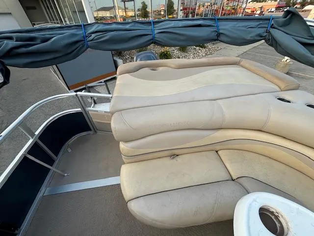 Slide: The Image of 2009 Bennington 2575RLi pontoon boat with beige seating and covered canopy. - 14
