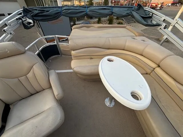 Slide: The Image of 2009 Bennington 2575RLi pontoon boat interior with beige seating and table. - 15