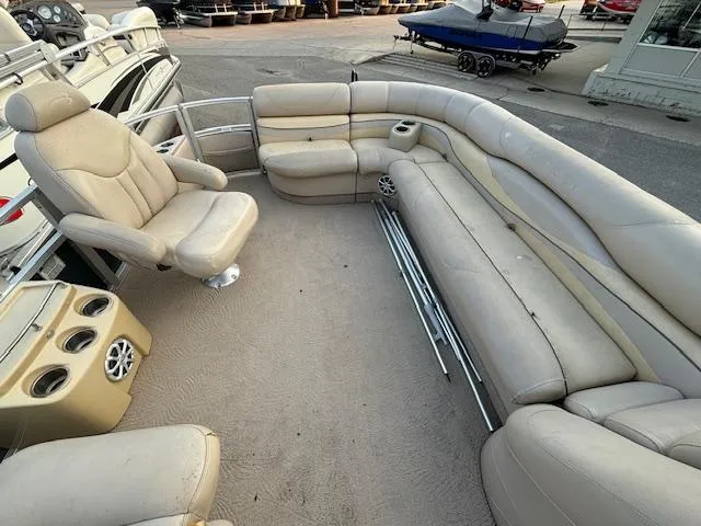 Slide: The Image of 2009 Bennington 2575RLi pontoon boat interior with beige seating and cup holders. - 2