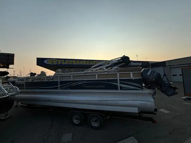 Slide: The Image of 2009 Bennington 2575RLi pontoon boat on a trailer at sunset. - 24