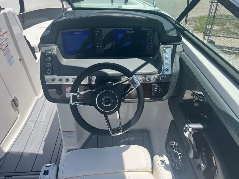 Slide: The Image of 2024 Chaparral 270 OSX boat cockpit with modern steering wheel and dual navigation screens. - 10