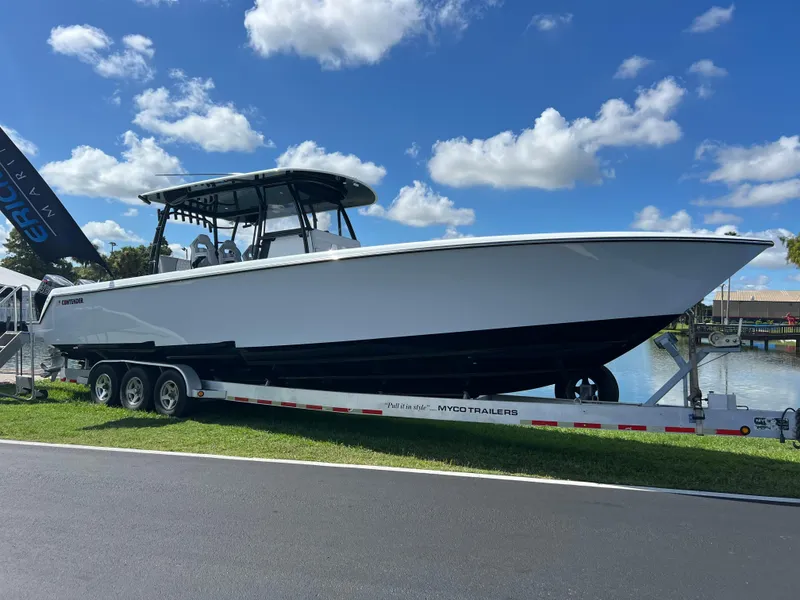 The Image of 2024 Contender 39 ST Center Console boat on trailer by the water. - 0