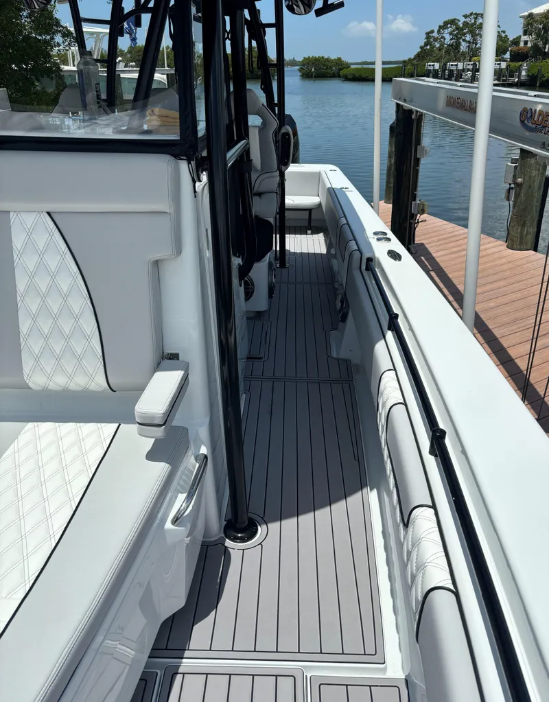 Slide: The Image of 2024 Contender 39 ST Center Console boat docked, featuring sleek white seating and modern design. - 15