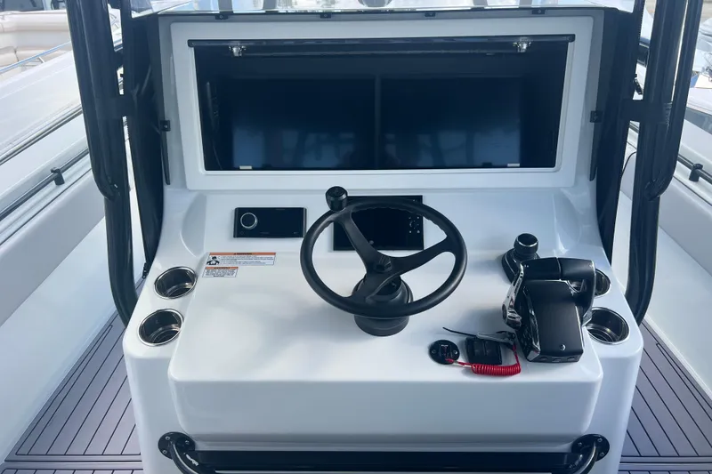 Slide: The Image of 2024 Contender 39 ST boat helm with steering wheel and control panel. - 28