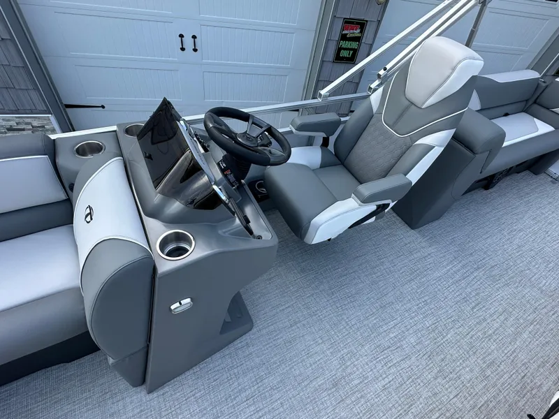 Slide: The Image of 2025 Tahoe Pontoon 2385 Sport 85 Quad Lounger Tri Toon interior with captain's chair and console. - 15