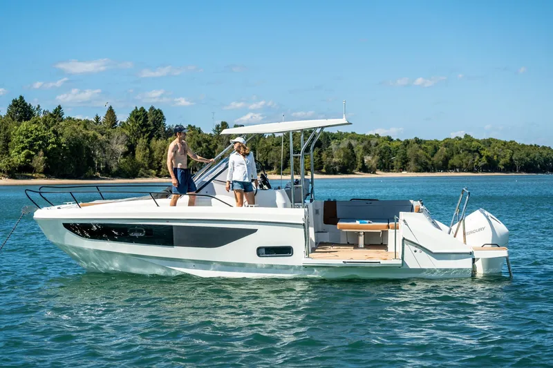 Slide: The Image of 2025 Beneteau Flyer 9 SUNdeck boat on a serene lake with lush green shoreline. - 10