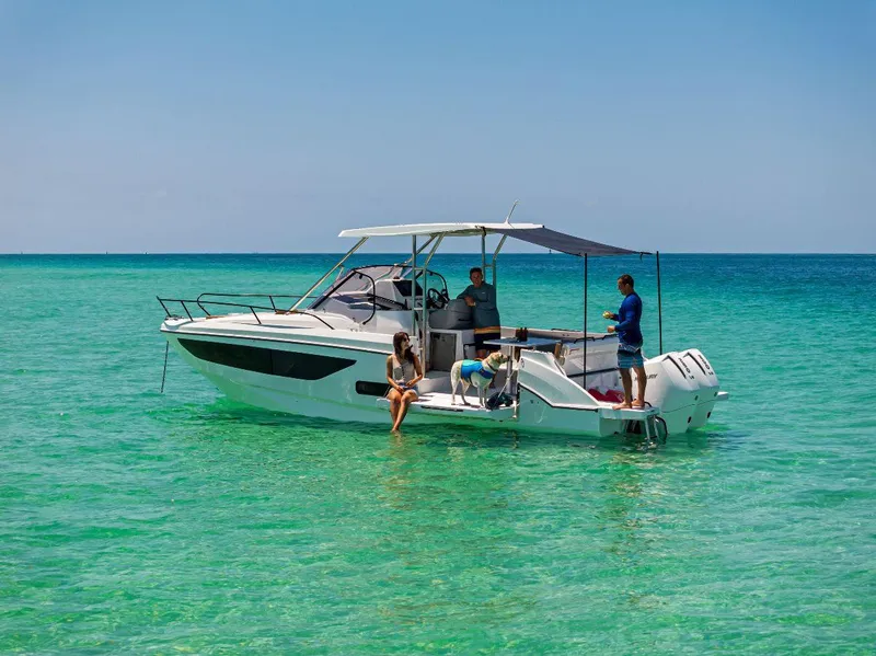 Slide: The Image of 2025 Beneteau Flyer 9 SUNdeck boat on clear turquoise water with people relaxing. - 4
