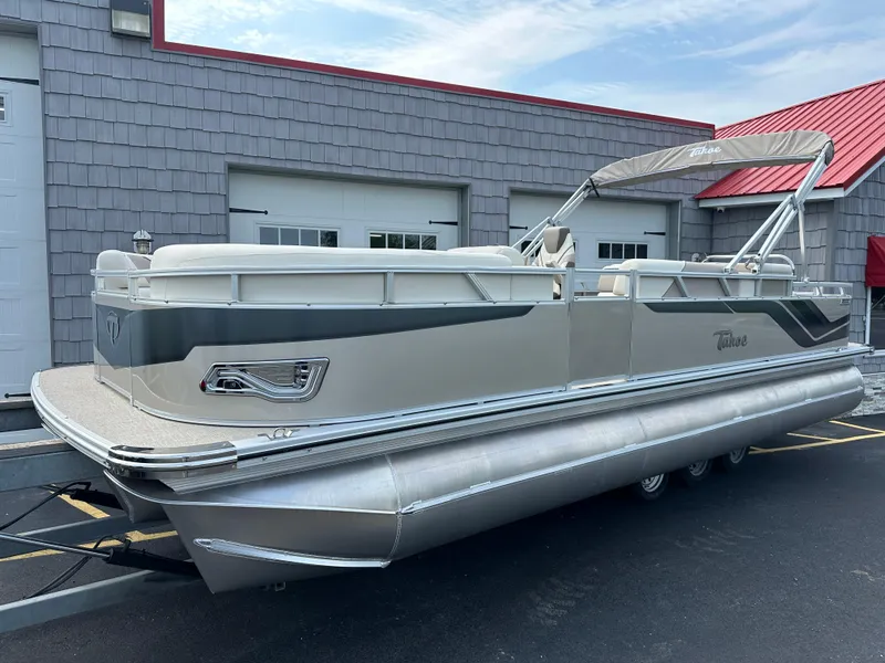 Slide: The Image of 2025 Tahoe Pontoon 2385 Sport 85, Rear Fish, Tri Toon, Sport Performance boat in front of a building. - 1