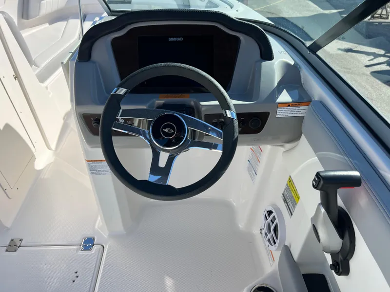 Slide: The Image of 2024 Chaparral 21 SSi OB boat dashboard with steering wheel and controls. - 11