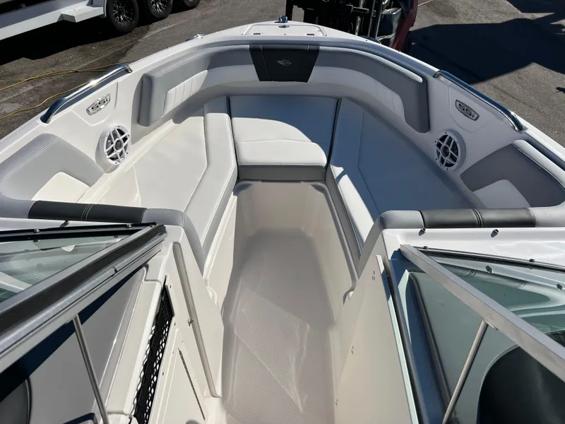 Slide: The Image of 2024 Chaparral 21 SSi OB boat interior with white seating and speakers. - 13