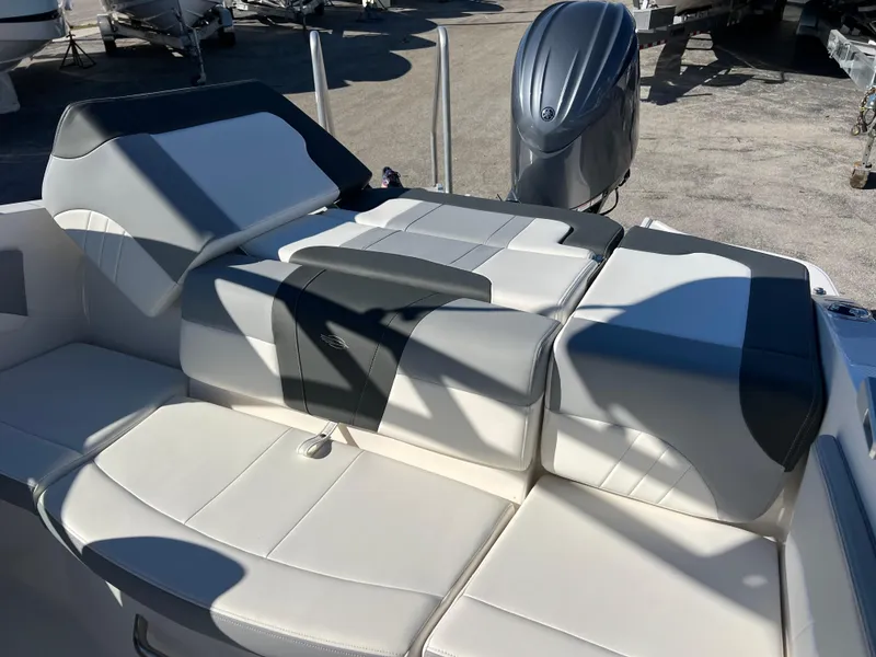 Slide: The Image of 2024 Chaparral 21 SSi OB boat interior with cushioned seating and outboard motor. - 18