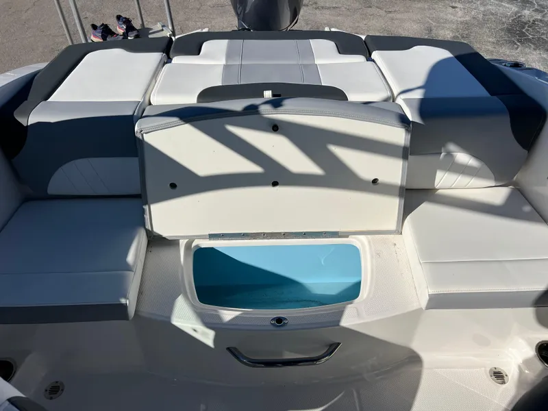 Slide: The Image of 2024 Chaparral 21 SSi OB boat interior with cushioned seating and storage compartment. - 21