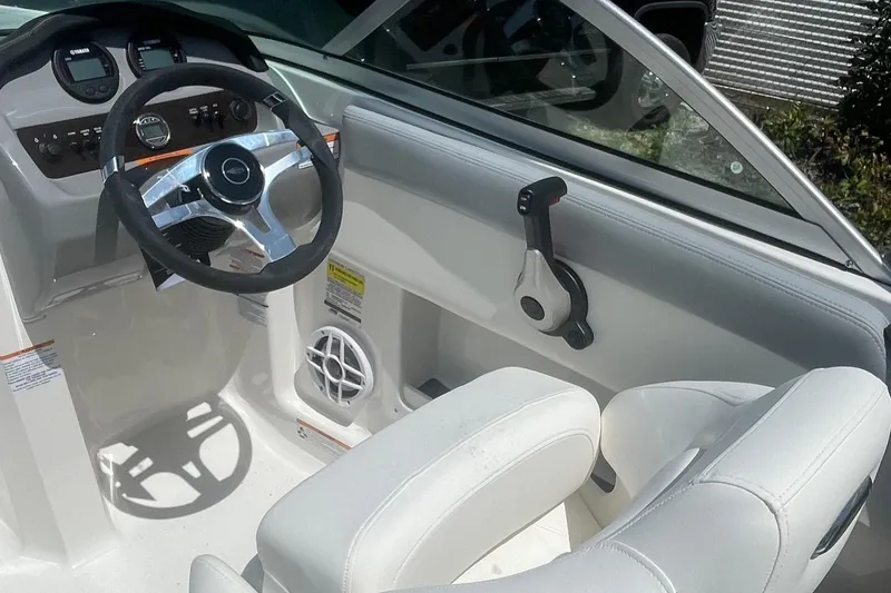 Slide: The Image of 2024 Chaparral 19 SSi OB boat interior with steering wheel and white seating. - 7