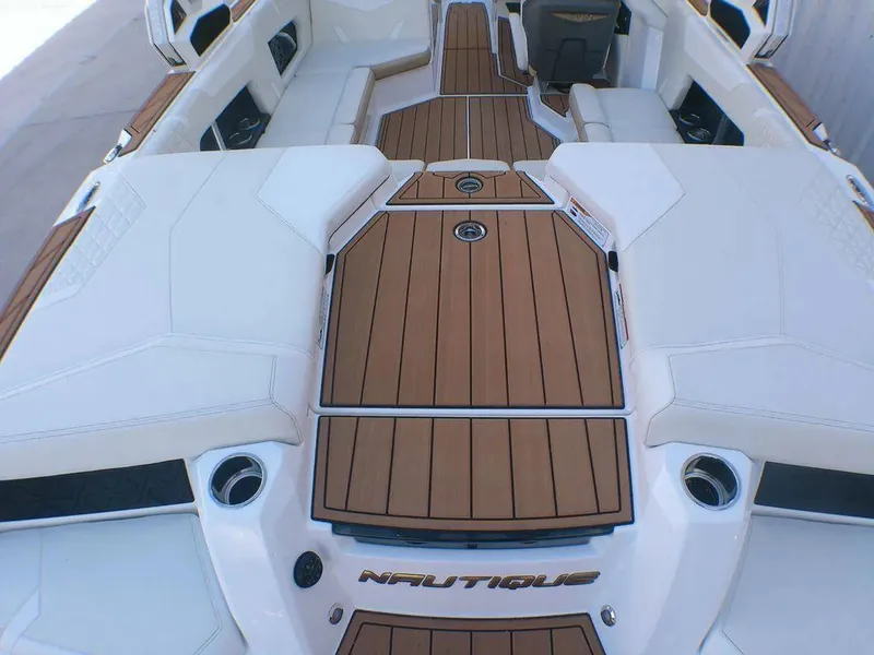 Slide: The Image of 2023 Nautique Super Air GS20 boat interior with teak flooring and white seating. - 8