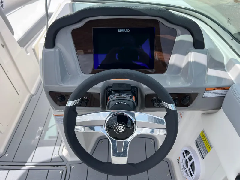 Slide: The Image of 2024 Chaparral 21 SSi OB boat dashboard with steering wheel and Simrad display. - 11