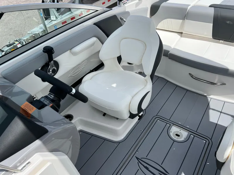 Slide: The Image of 2024 Chaparral 21 SSi OB boat interior with white captain's chair and gray flooring. - 14