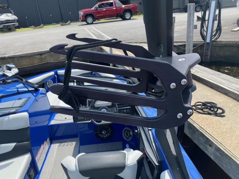 Slide: The Image of Axis T220 2022 boat with wakeboard rack, docked near a red truck. - 11