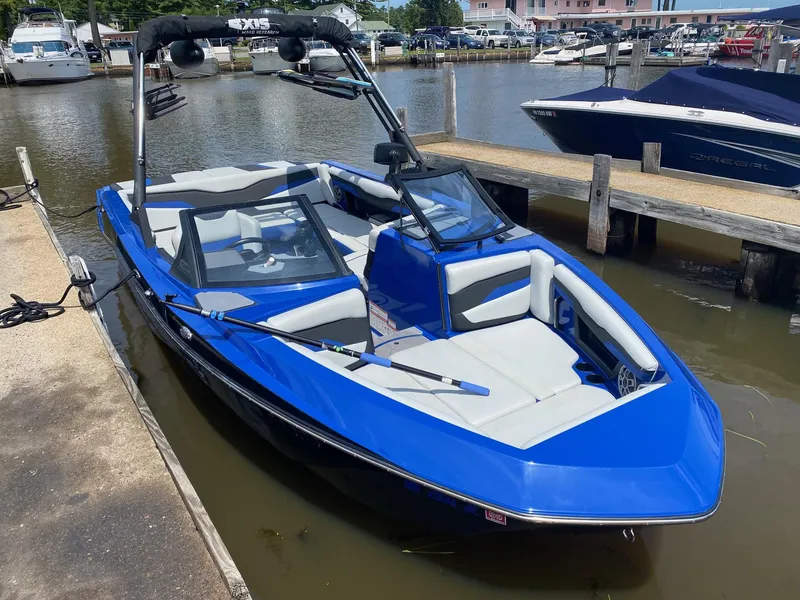 Slide: The Image of 2022 Axis T220 blue boat docked at marina. - 2