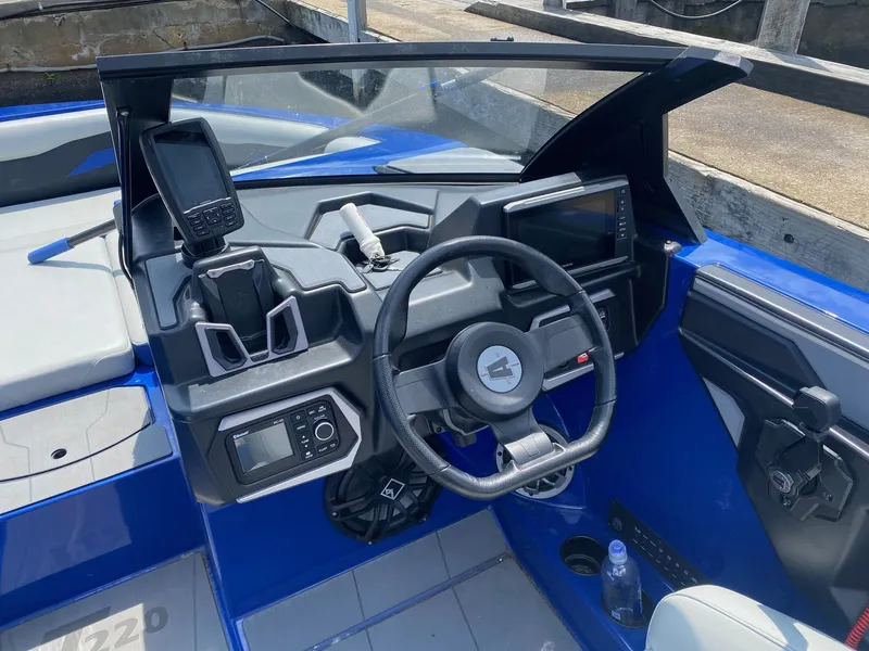 Slide: The Image of 2022 Axis T220 boat dashboard with steering wheel, navigation system, and control panel. - 5