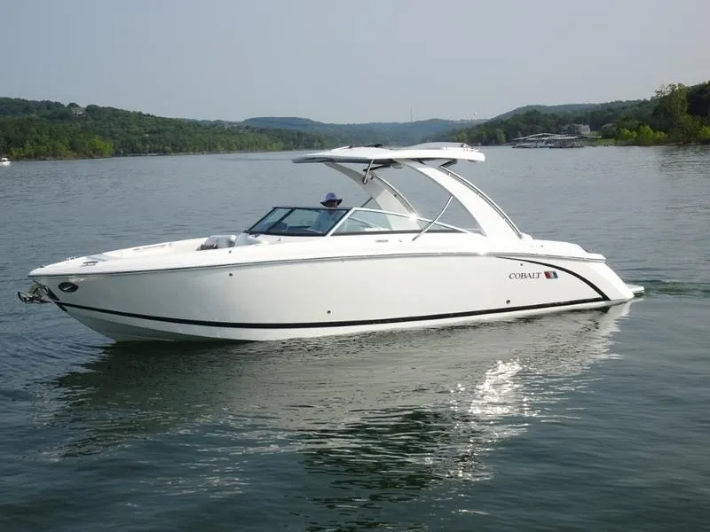 Slide: The Image of 2025 Cobalt R30 boat cruising on a serene lake with lush green hills in the background. - 11