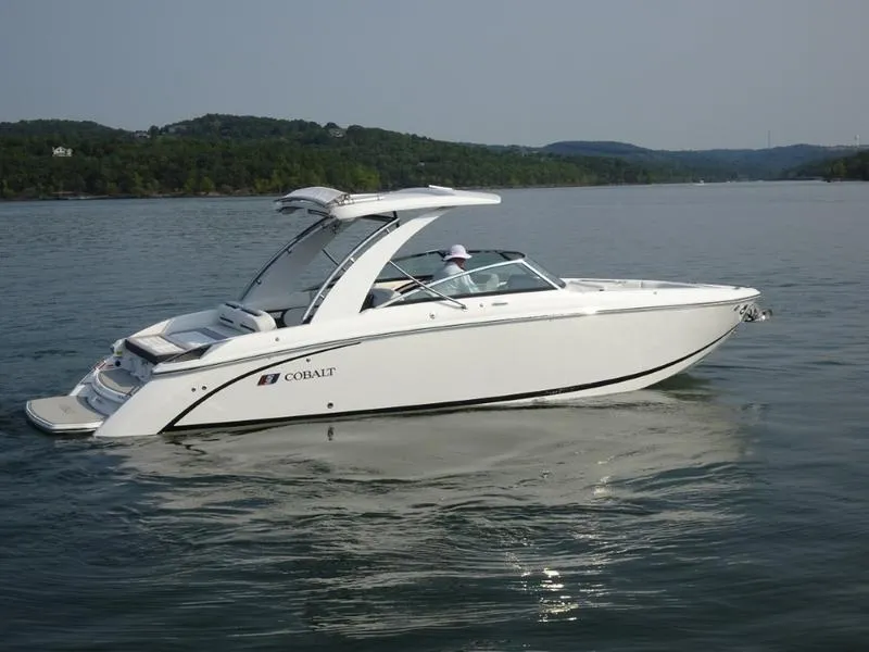 Slide: The Image of 2025 Cobalt R30 boat cruising on a serene lake with forested hills in the background. - 4