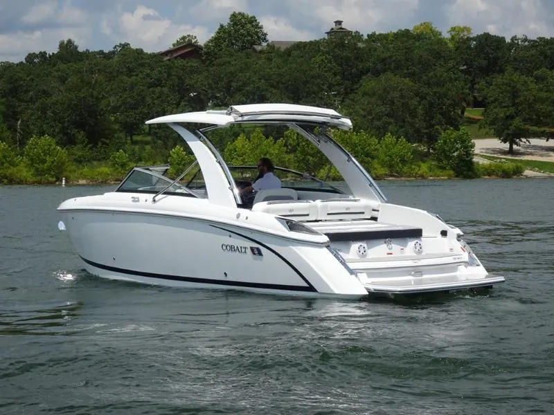 Slide: The Image of 2025 Cobalt R30 boat cruising on a lake with lush green trees in the background. - 6