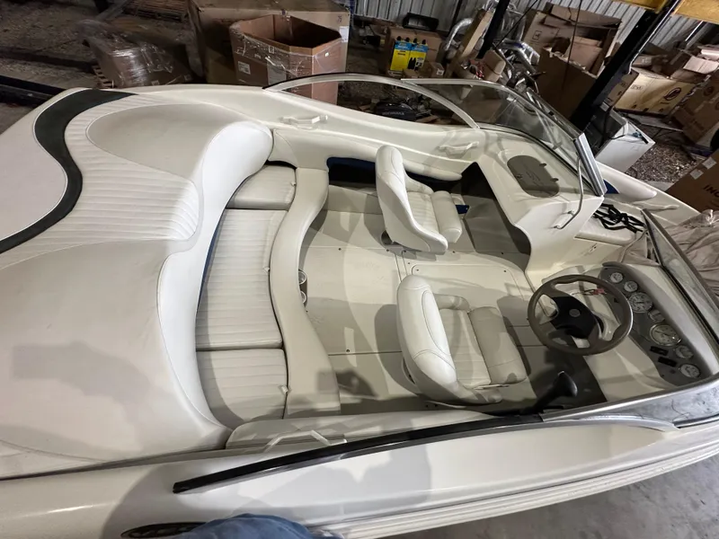 Slide: The Image of 2004 Glastron SX175 boat interior with white seating and dashboard in a storage area. - 13
