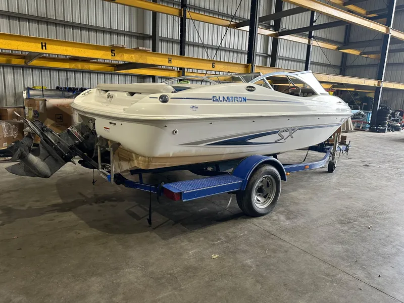 Slide: The Image of 2004 Glastron SX175 boat on a blue trailer in a warehouse. - 14