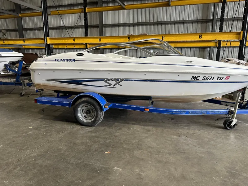 Slide: The Image of 2004 Glastron SX175 boat on a blue trailer in a storage facility. - 15