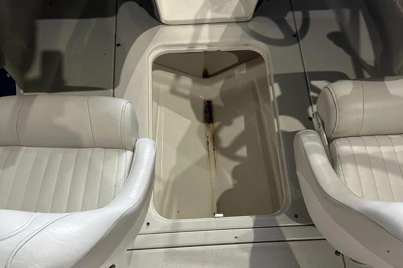 Slide: The Image of 2004 Glastron SX175 boat interior with storage compartment and white seats. - 19