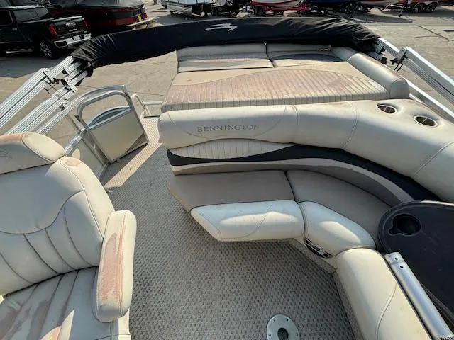 Slide: The Image of 2007 Bennington 2275RL pontoon boat interior with beige seating and cup holders. - 4
