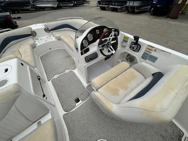 Slide: The Image of 2007 Hurricane 202FD boat interior with worn seats and steering console. - 10