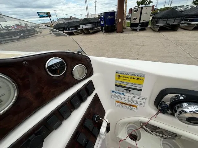 Slide: The Image of 2007 Hurricane 202FD boat dashboard with capacity label, marina background. - 12