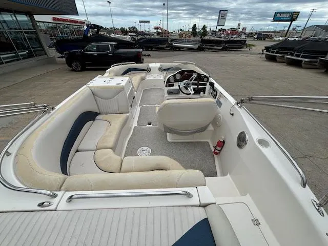 Slide: The Image of 2007 Hurricane 202FD boat interior with seating and steering wheel, parked at a dealership. - 8