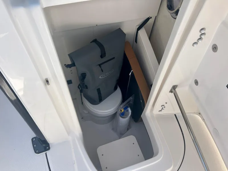 Slide: The Image of 2025 Robalo R270 boat interior storage compartment with toilet and accessories. - 31