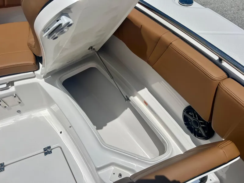 Slide: The Image of 2025 Robalo R270 boat storage compartment with brown seating and white interior. - 34