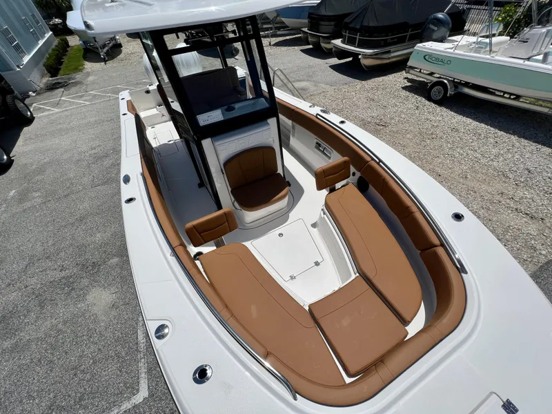 Slide: The Image of 2025 Robalo R270 boat with tan seating and white deck in a marina. - 36