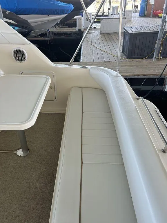 Slide: The Image of 1997 Sea Ray 330 Sundancer boat interior with white seating and table. - 10