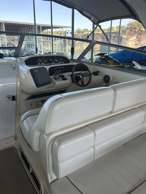 Slide: The Image of 1997 Sea Ray 330 Sundancer cockpit with white seating and steering wheel. - 12