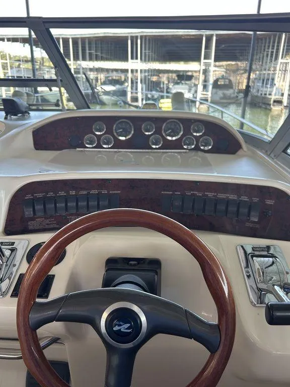 Slide: The Image of 1997 Sea Ray 330 Sundancer helm with wood-trimmed steering wheel and control panel. - 20