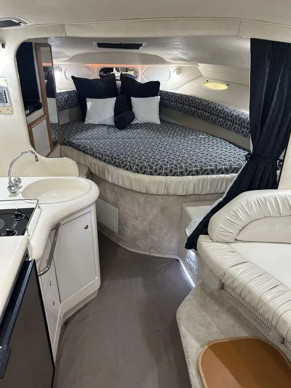 Slide: The Image of 1997 Sea Ray 330 Sundancer cabin with bed, kitchenette, and seating area. - 23