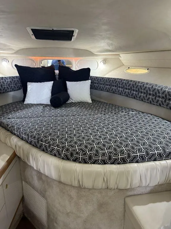 Slide: The Image of 1997 Sea Ray 330 Sundancer cabin with patterned bedding and pillows. - 26