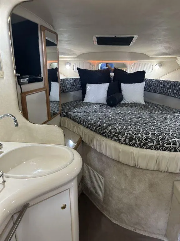 Slide: The Image of 1997 Sea Ray 330 Sundancer cabin with bed, sink, and storage. - 28