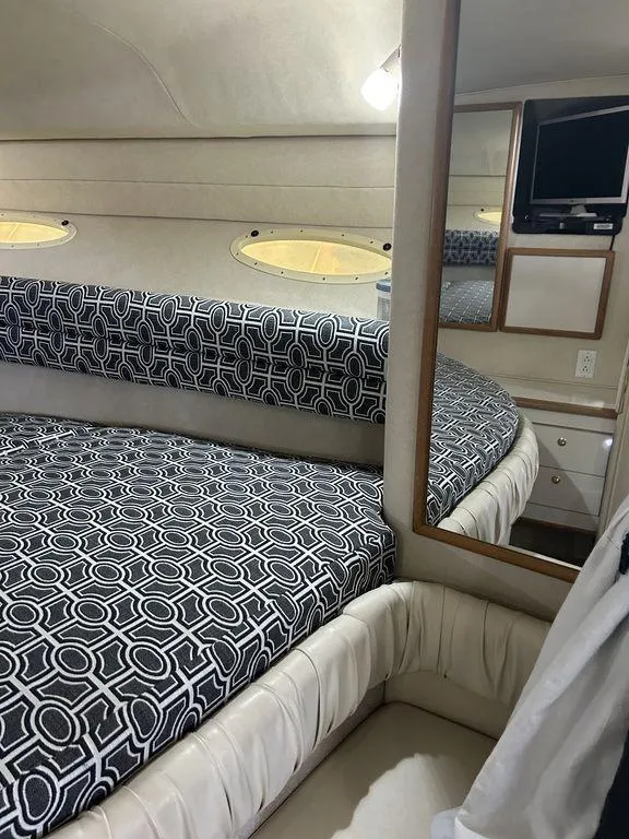 Slide: The Image of 1997 Sea Ray 330 Sundancer cabin interior with bed and TV. - 29