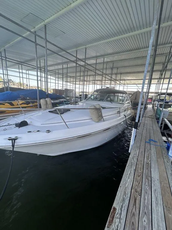 Slide: The Image of 1997 Sea Ray 330 Sundancer docked in a covered marina. - 3