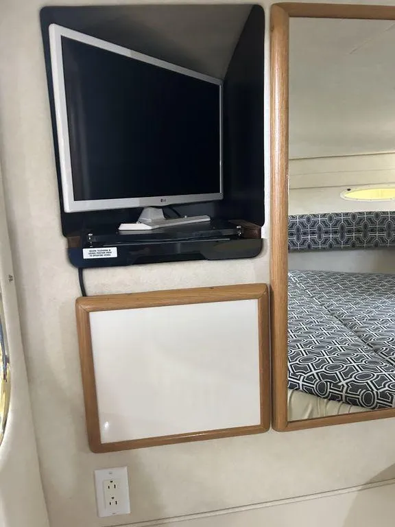 Slide: The Image of 1997 Sea Ray 330 Sundancer interior with TV, mirror, and bed. - 30
